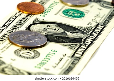 close up of a a dollar bill with cent coins over a white background. symbol of wealth - Shutterstock ID 1016626486