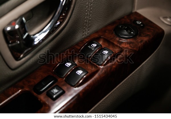 Close up of a door control panel in a new\
modern car. Arm rest with window control panel, door lock button,\
and mirror control.\
