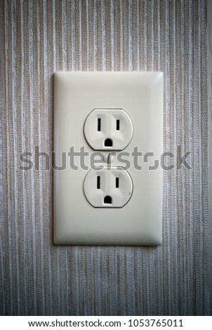 close up of a double electric socket on a wall