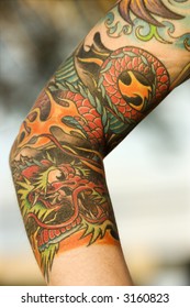 Close Up Of Dragon Tattoo On Arm Of Caucasian Woman.