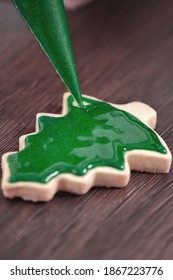 Close Up Of Drawing Gingerbread Christmas Tree Sugar Cookie On Wooden Table Background With Green Icing, Concept Of Holiday Celebration.