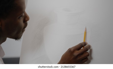 Close Up Of Drawing Of Vase With Black Hand Holding Pencil On White Fine Art Canvas In Artwork Space. African American Young Artist Working On Modern Design For Professional Masterpiece