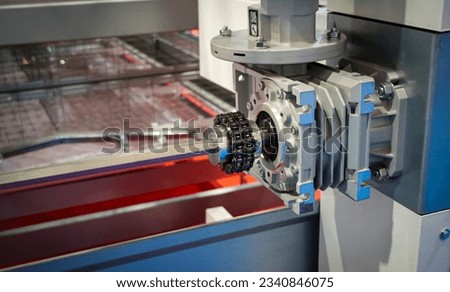 Close up of drive sprockets and industrial drive roller chains in production machine line without safety guard, tensioners in engine. Industrial technology. Team work, business concept, horizontal