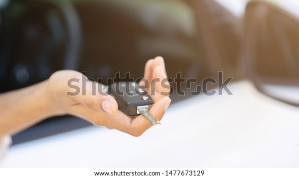 close up\
driver chauffeur adult man hand holding car\'s key and showing\
outside window for safety and insurance\
concept
