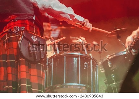 Close up of drummer's hands, of man in Scottish skirt, selective focus. Holiday of St. Patrick's Day