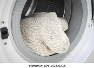 Close up dry wool sweater knitwear been washed with wool program in modern washing machine for sweater.