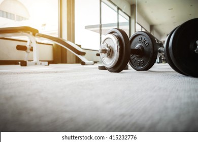 Close Up Of Dumbbell Exercise Weights On The Floor At Fitness Gym With Copy Space.