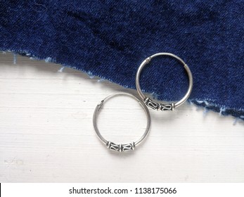 Close up of earring minimal style jewelry silvers is a big hoops earring,on whit wooden minimal style.