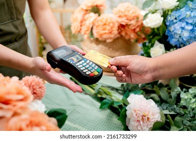 Close up of easy payment by credit card or smartphone application Greenhouse workers selling pottered flowers.Contactless payment with credit card customer at counter using QR code contactless payment - Powered by Shutterstock