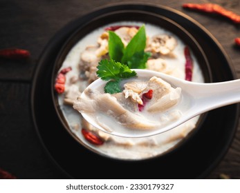 Close up of eating coconut milk soup with chicken in bowl. Favorite Thai food ( Tom kha gai )