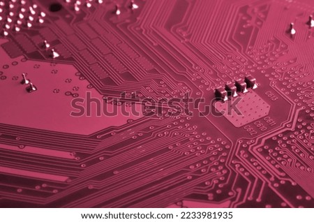 Close up of ed micro circuit board. Abstract technology background. Computer mechanism in details. Image toned in Viva Magenta, color of the 2023 year