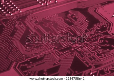 Close up of ed micro circuit board. Abstract technology background. Computer mechanism in details. Image toned in Viva Magenta, color of the 2023 year