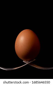 close up of an egg balanced of two forks