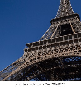 close up of Eiffel Tower in Paris against clear blue sky