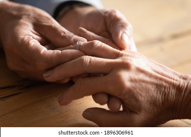 Close Up Elder Senior Man Putting Engagement Ring With Diamond On Finger Of Middle Aged Woman, Making Marriage Proposal. Happy Old Retired Couple Planning Wedding, Romantic Relations, Love Concept.