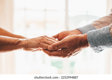 Close up elderly affectionate woman covering wrinkled hands of mature husband, showing love and support at home. Caring middle aged family couple enjoying sincere trustful honest conversation. - Powered by Shutterstock