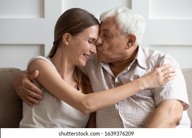 Close Up Of Elderly Father Cuddle Hug Grownup Daughter Kiss Her Show Love And Care, Mature Dad And Adult Female Child Relax On Couch Share Tender Intimate Family Moment, Enjoy Weekend Together