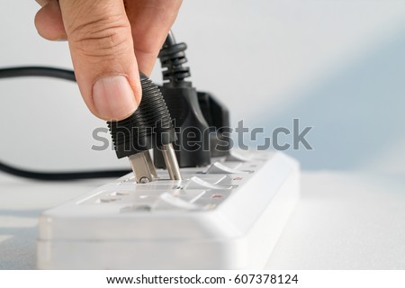 Close up Elderly hand plugging into electrical outlet