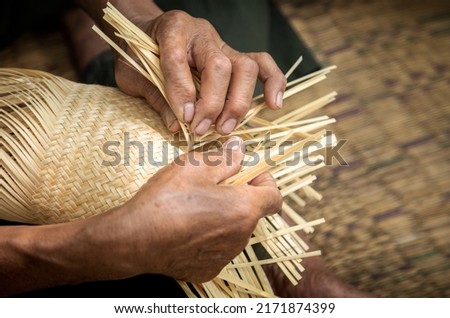 Close up of elderly hands manually weaving bamboo basket, handicraft traditional, basketweave