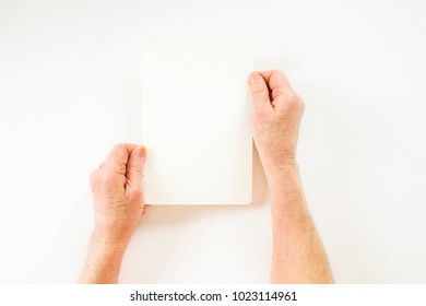 Close Up Of Elderly Woman, Hands Holding Blank Empty Sheet. Old Lady Wrinkled Arms, Clearly Visible Veins & Freckles, Recipe, Piece Of Paper. Isolated White Background, Overhead, Copy Space