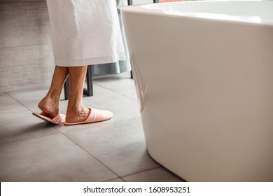 Close up of elderly woman legs in comfortable house shoes stock photo