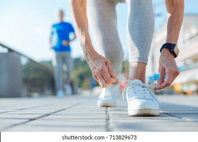 Close up of elderly woman tying shoelaces on sneakers - Powered by Shutterstock