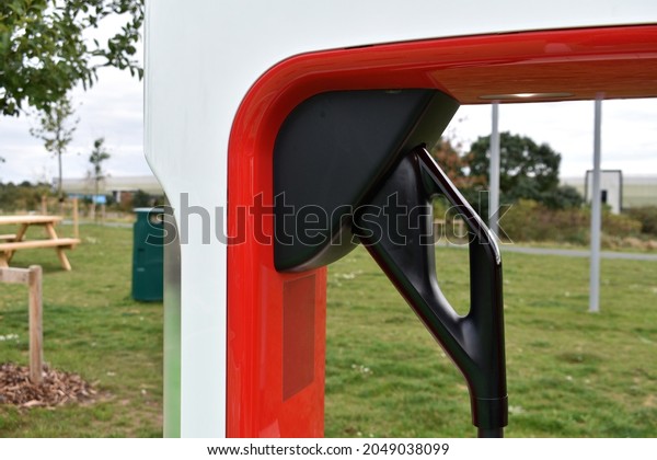 close up of an electric\
car charging handle in recharging point at service station outside\
in autumn