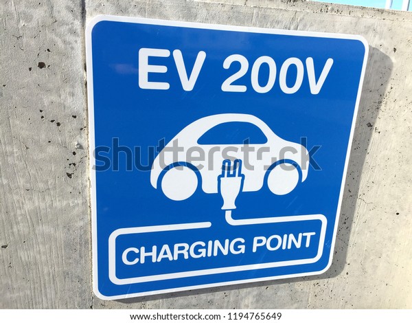 Close up of an Electric Car Charging\
Point signage (EV 200V charging point) on a\
wall