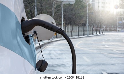 Close Up Of Electric Car Inlet On A Background Of Snowy City Street