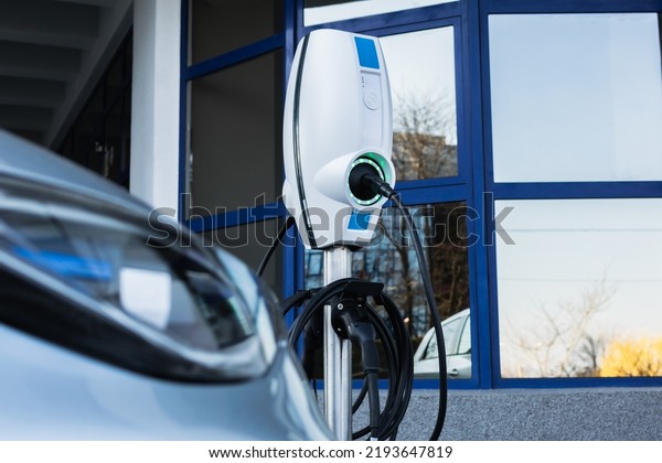 Close up of\
electric car next to charging\
station