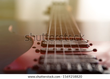 Close up electric guitar stings and magnets, soft focus, shallow depth of field.
