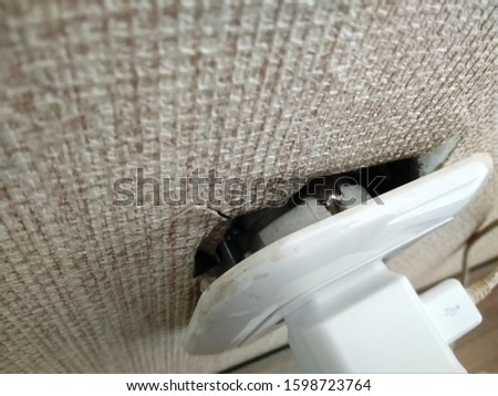 close up of the electrical outlet which was almost dislodged from the wall,soft selective focus