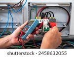 Close up electrician checking voltage from home use solar cell combiner box 