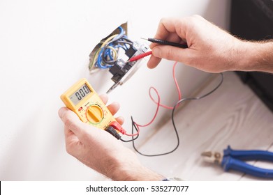 Close Up Of Electrician Hands  Fixing A Socket