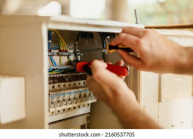 Close up of electrician hands who fix the electric box on construction site - Shutterstock ID 2160537705