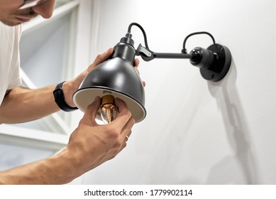 Close Up Of Electrician Worker Maintenance - A Man Changes A Light Bulb To An Energy-saving One