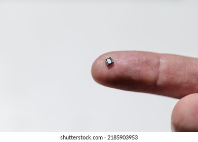 Close Up Of Electronic Microchip On Human Finger.