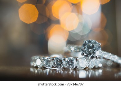 Close up of an elegant diamond ring on the table with bokeh background. soft and selective focus. Love and wedding concept.