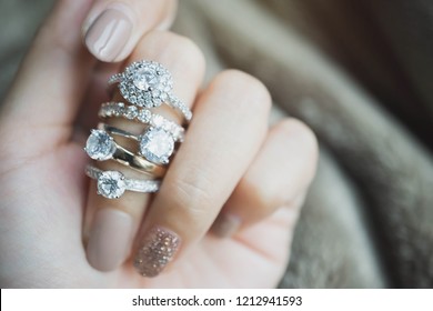 Close up of an elegant diamond rings on woman finger.love and wedding concept.soft and selective focus. - Shutterstock ID 1212941593
