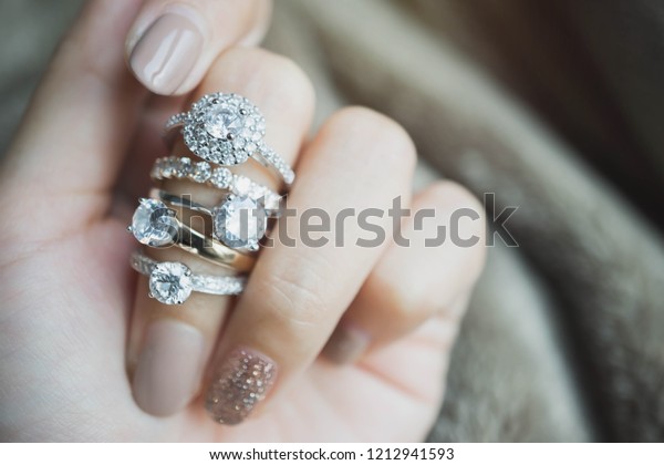 Close up of an elegant\
diamond rings on woman finger.love and wedding concept.soft and\
selective focus.