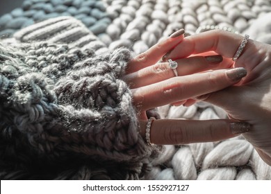 Close Up Of An Elegant Engagement Diamond Ring On Woman Finger With Dark Gray Sweater Winter Clothe. Love And Wedding Concept.soft And Selective Focus.