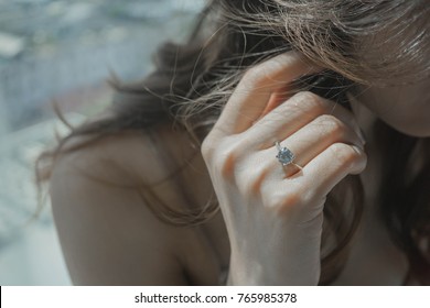 Close Up Of An Elegant Engagement Diamond Ring On Woman Finger. Love And Wedding Concept.