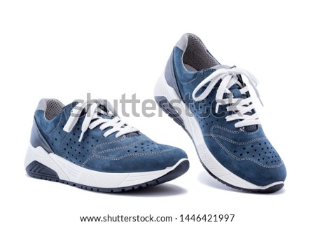 Close up of elegant light blue sports shoes in natural nubuck leather for adult men photographed on a white background. Fashion accessories.