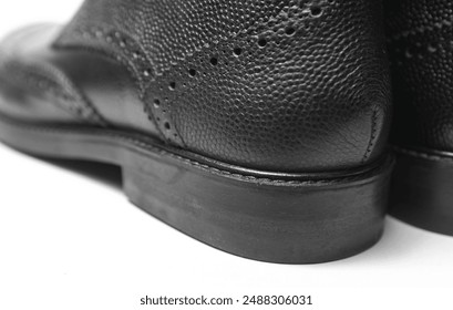 Close up elements of black leather boots on white background