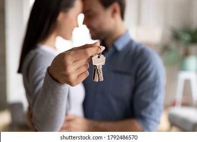 Close up emotional happy family couple demonstrating keys from new house or paid apartment to camera. Smiling positive spouses celebrating first flat purchase, successful investment or renovation. - Shutterstock ID 1792486570