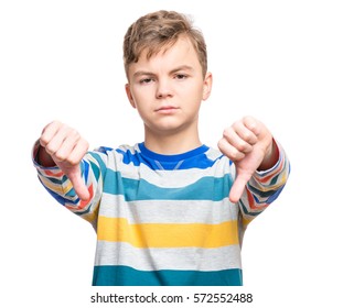 Close Up Emotional Portrait Of Caucasian Unhappy Teen Boy Giving Thumbs Down Hand Gesture. Angry Child Looking With Disapproval Facial Expression, Isolated On White Background. Negative Human Face