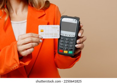 Close up employee business woman corporate lawyer wear classic formal orange suit glasses work in office hold bank payment terminal to process acquire credit card isolated on plain beige background - Shutterstock ID 2250641825