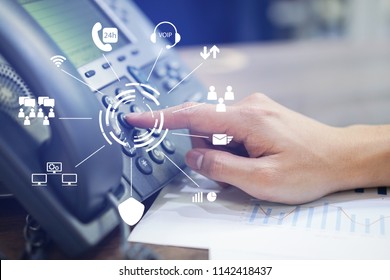 close up employee call center man hand point to press button number on telephone office desk with virtual communication technology concept