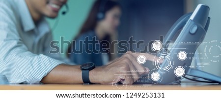 close up employee call center man hand point to press button number on telephone office desk with virtual communication technology concept
