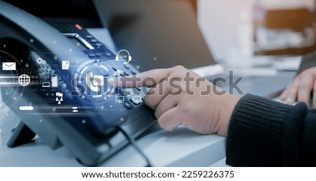close up employee call center woman hand point to press button number on telephone office desk with virtual communication technology concept